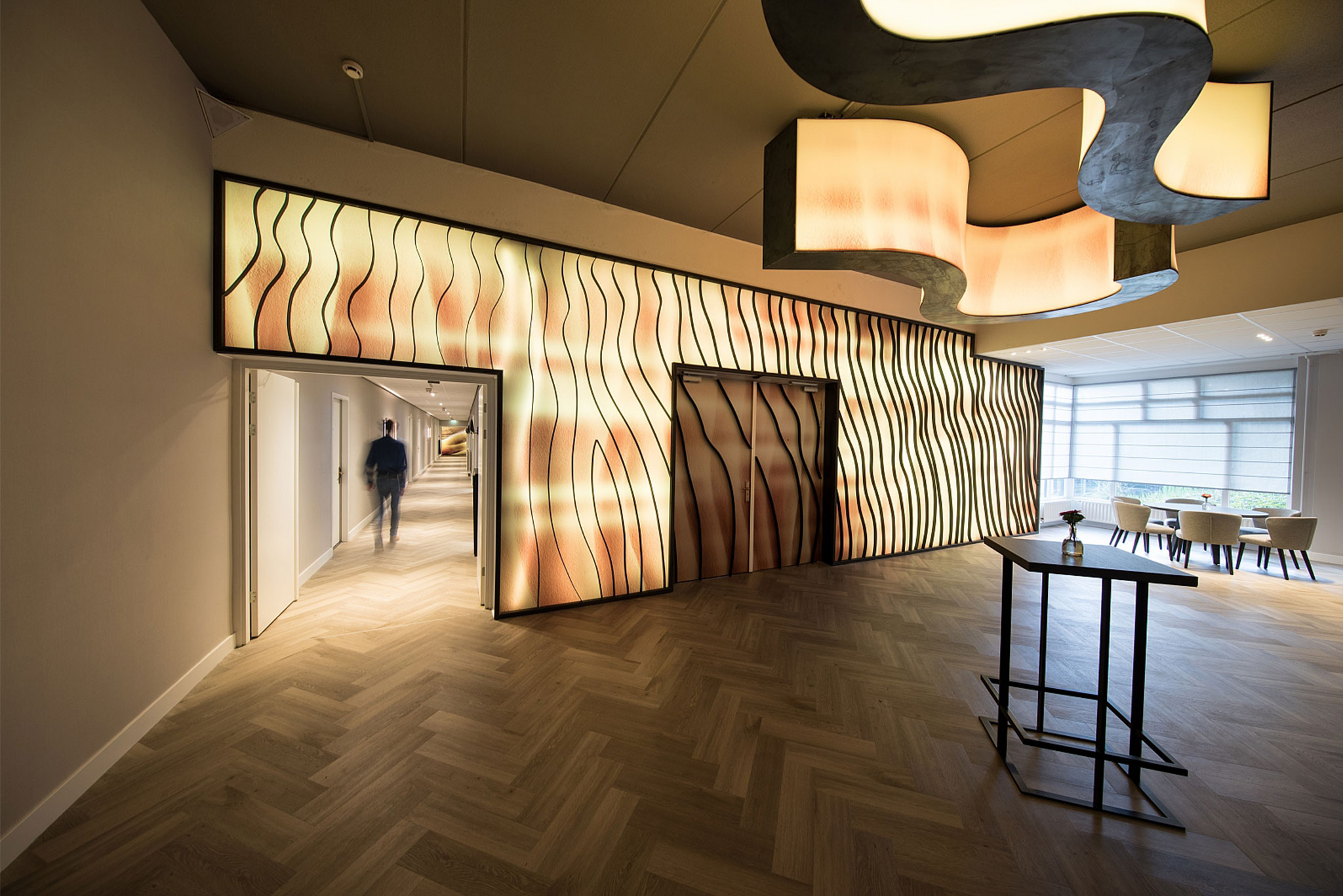 Maatwerk interieurdecoratie met een verlichte wand in een bedrijfspand